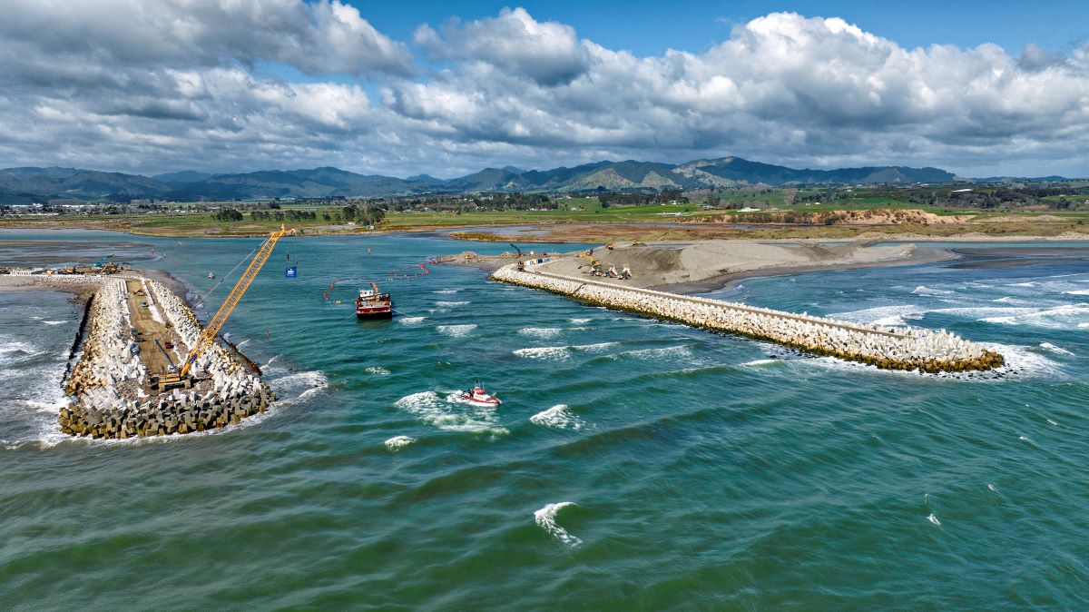 A picture of a coastguard boat going out to sea through the Opotiki harbour walls