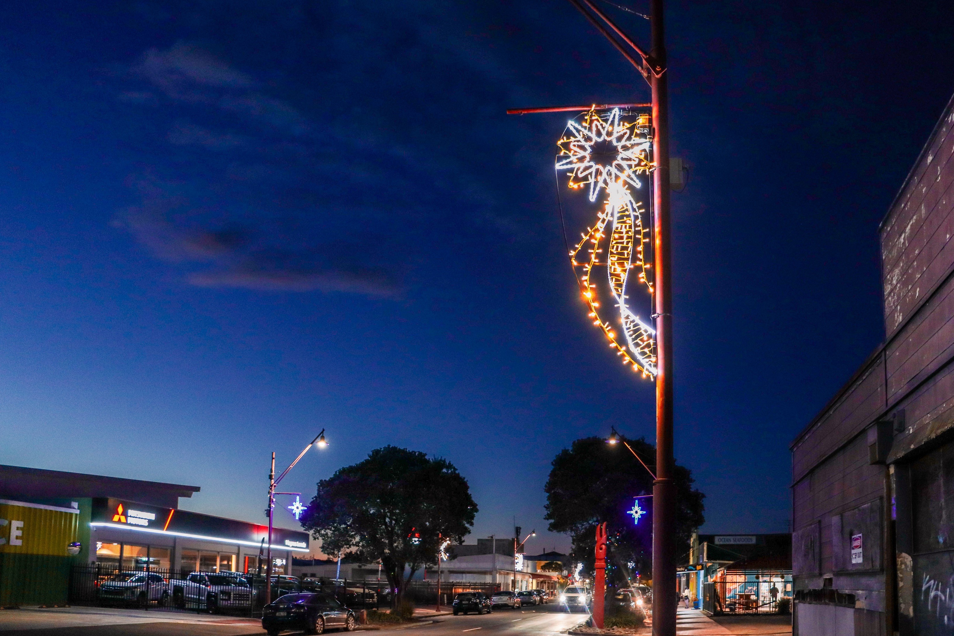 Evening sky across town with a bright colourful neon light in the foreground of a star with blazing rays.