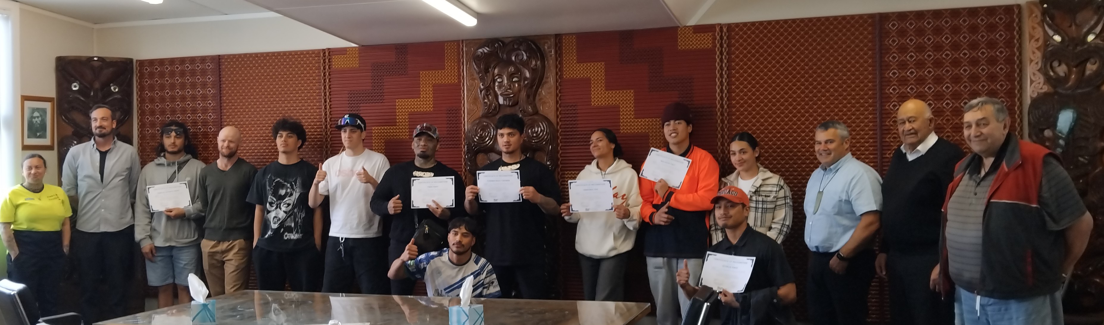 Line of young people holding certificates in the Whakatohea boardroom 