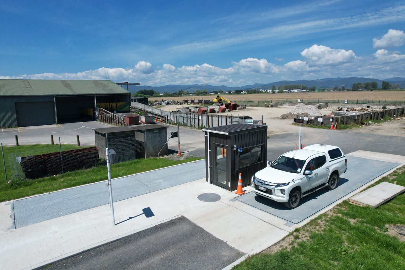 Sunny day at a municipal recycling plant, an elevated view of council vehicle using a new weigh station.  